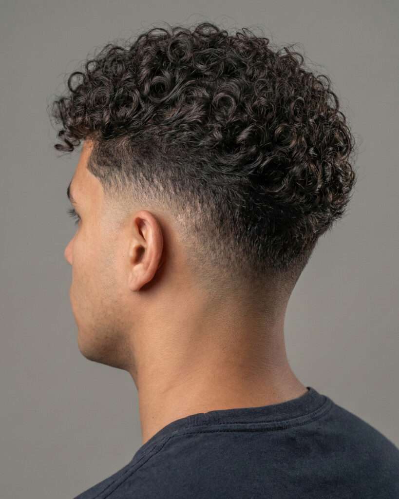 homem com corte de cabelo masculino low fade com cachos naturais