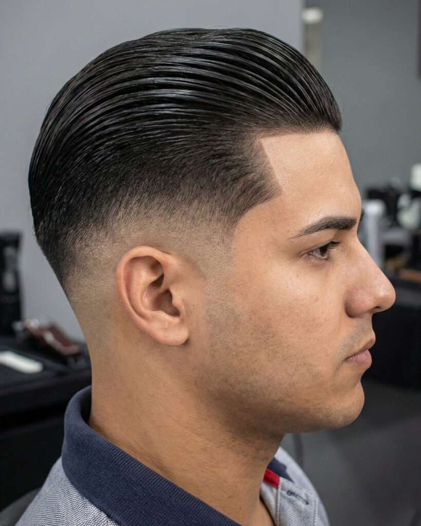 Homem com corte de cabelo degradê com cabelo liso para trás