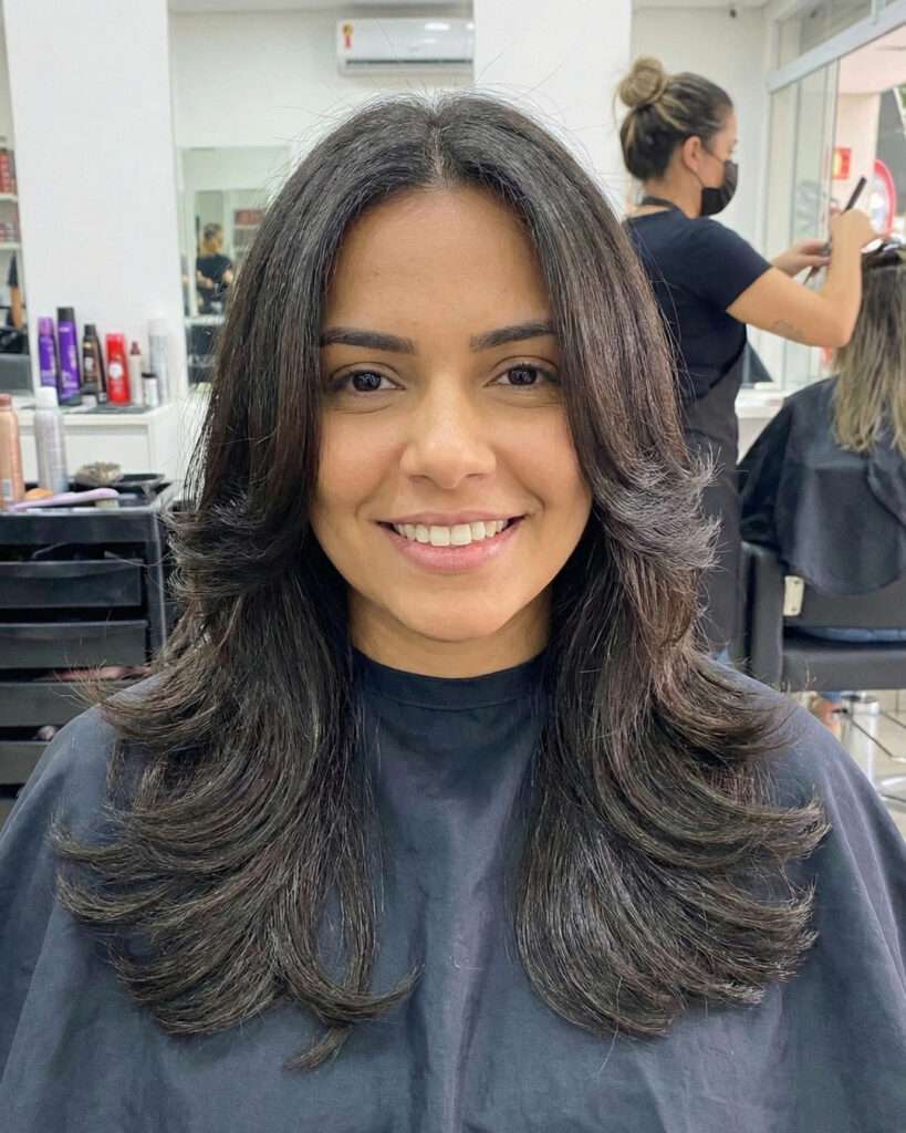 Butterfly cut castanho longo com camadas em cascata em salão de beleza